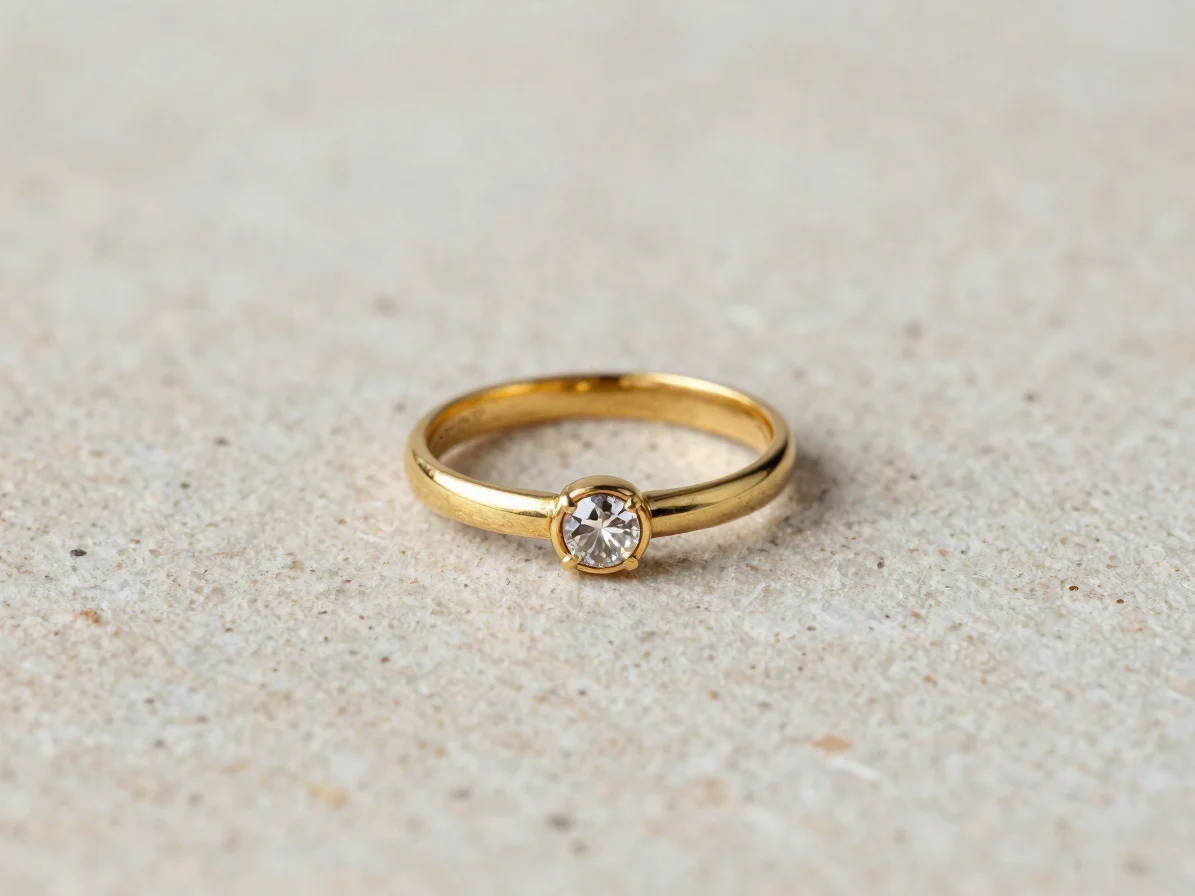 Macro studio photograph of a single gold ring with a small facete